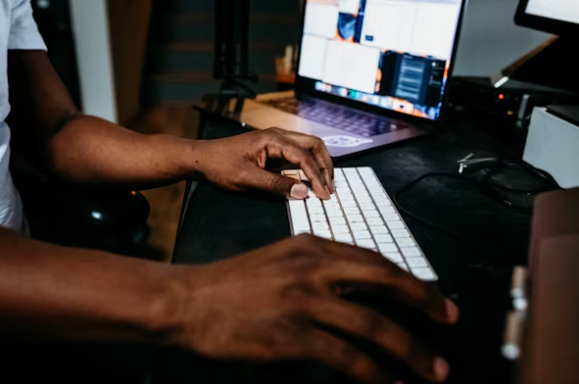 A person using a laptop, probably a good digital citizen, who is checking the recent trends in Nigerian scam syndicates