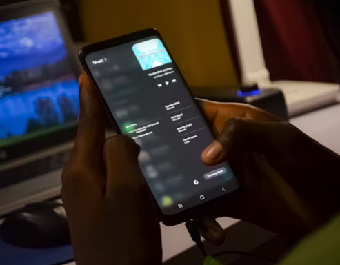 A person holding a smartphone showing scam call details—highlighting why Nigerian scams continue to succeed in 2025